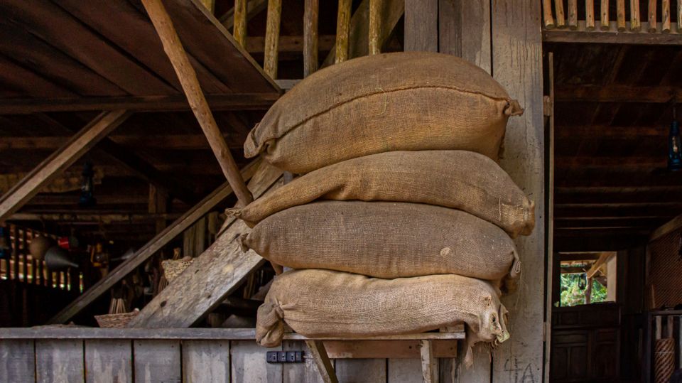 Feed sacks stacked on a wooden shelf inside a barn.